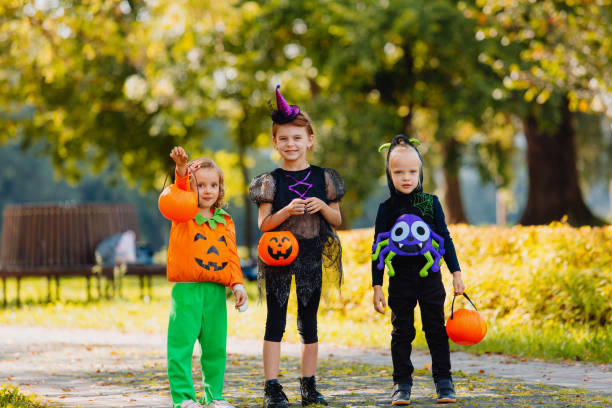 istock Happy Halloween. three running kids with a basket for sweets 1346413706