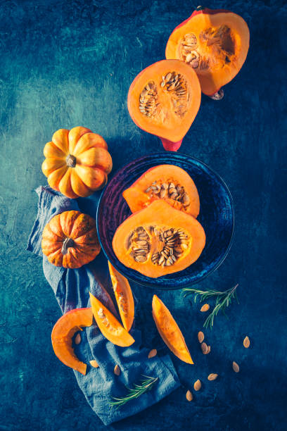 istock Organic pumpkin with seeds ready for cooking on blue background 1346414959