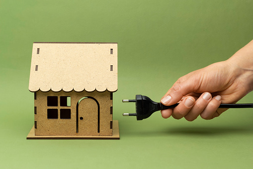 Conservation of the environment, ecological concept, green energy. Model house and plug.