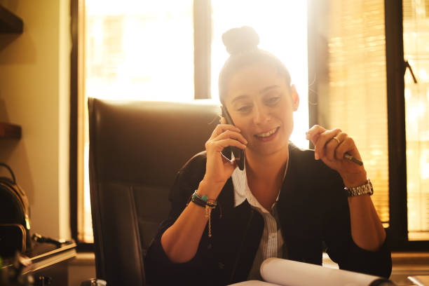 Young business woman making phone call while in her office