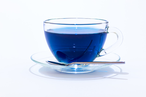 Cup of Anchan or Butterfly pea tea. Blue tea in a transparent glass cup isolated on white background