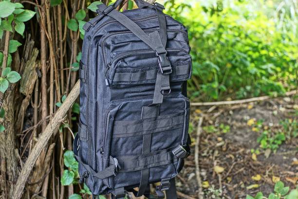 istock one large black tactical backpack hanging on the brown branches 1346420563
