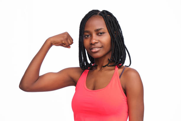 istock Young adult woman showing biceps while looking at camera on a white background 1346421128