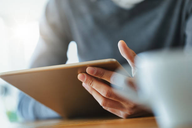 istock Hand of a Black man holding a tablet pc 1346422338