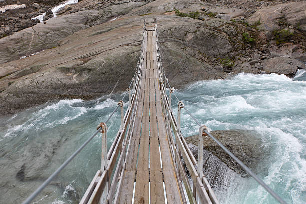 Bridge over troubled glacial water stock photo