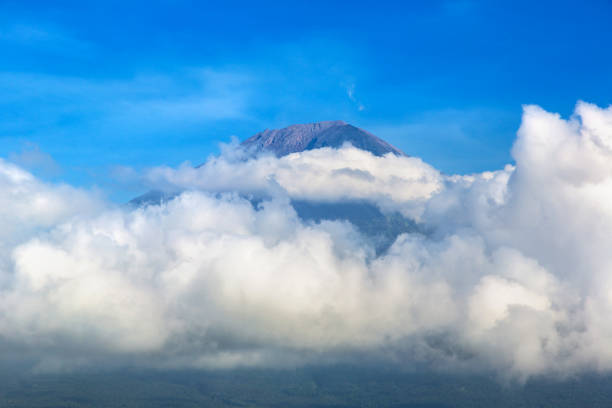 Beautiful view at active volcano mount Agung surrounding clouds on Bali, Indonesia in a sunny day