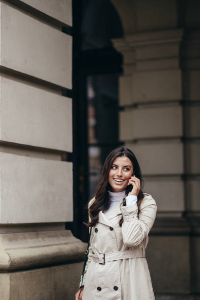 istock Beautiful young woman using a smartphone while out in the city 1346428606