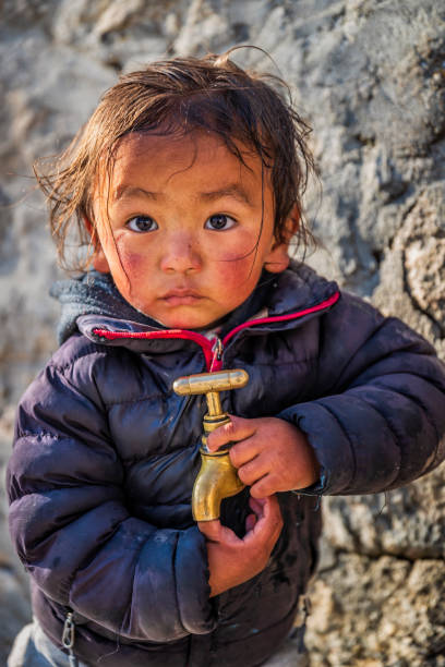 menina nepalês brincando com uma torneira de água, parque nacional do monte everest, nepal - indian culture child little girls indigenous culture - fotografias e filmes do acervo