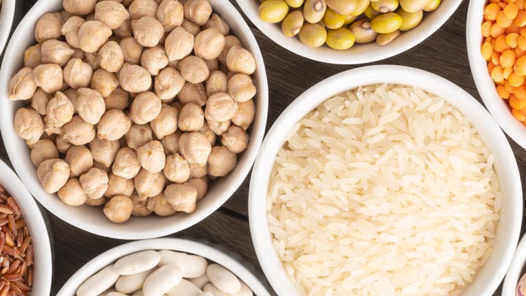 Rotating assorted beans and grains on white bowls