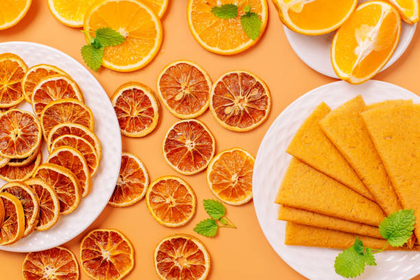 orange pastille and fruit chips, frips.close-up mix sliced dried fruits in craft paper box and mix fruit pastille marshmallow in white plate. vegetarian lifestyle.pastille handmade - pastilles imagens e fotografias de stock