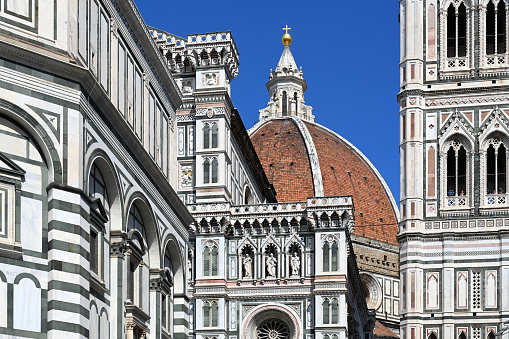 Image of famous cathedral Duomo Santa Maria del Fiore, Florence Baptistery and Giotto's Campanile tower against blue summer sky located in Florence, Tuscany, Italy, Europe