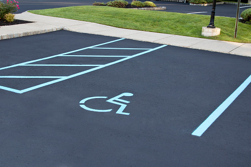 Freshly paved, painted, and lined handicapped parking area.