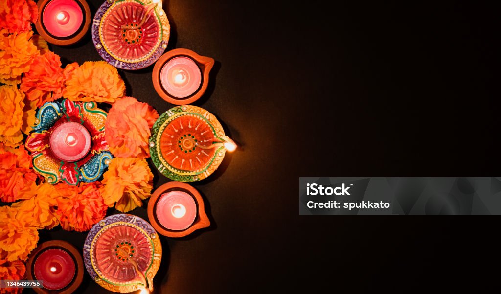 Happy Diwali - Clay Diya lamps lit during Dipavali, Hindu festival of lights celebration. Colorful traditional oil lamp diya on black background Diwali Stock Photo