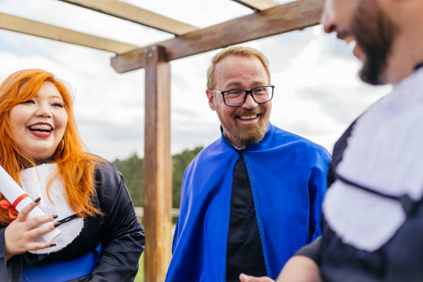 istock Smiling teacher and students at graduation 1346443429