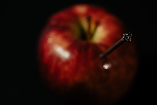 a red apple and nails on it