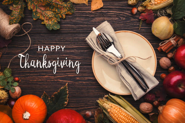 istock Happy Thanksgiving background with festive table setting. Pumpkins, nuts, fallen leaves and spices on wooden table with text 1346446155