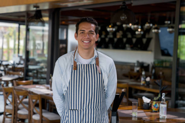 istock Happy waiter working at a restaurant and smiling 1346447929