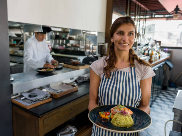 istock Waitress working at a restaurant and serving food 1346447975
