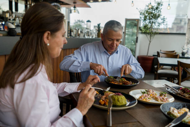 feliz cena familiar juntos en un restaurante - carnivore fotografías e imágenes de stock