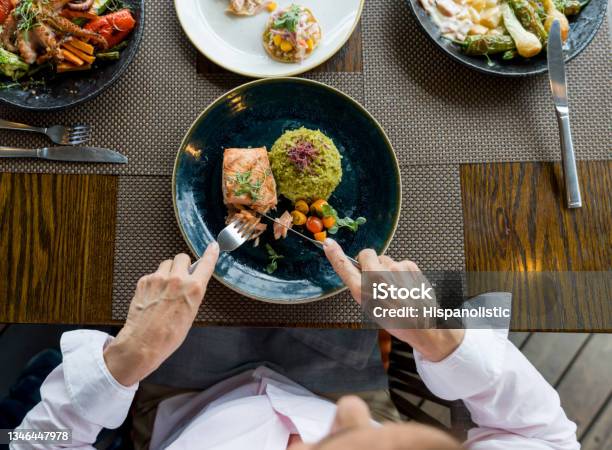 Closeup On A Woman Eating Salmon For Dinner At A Restaurant Stock Photo - Download Image Now