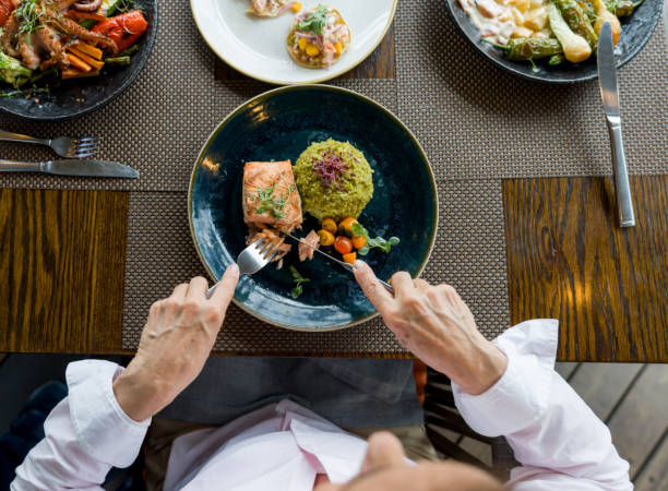 zbliżenie na kobietę jedzącą łososia na kolację w restauracji - carnivore zdjęcia i obrazy z banku zdjęć