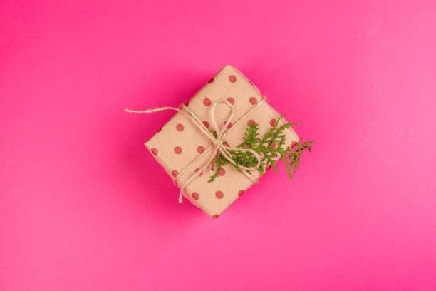 istock Top view of a decorated present with a bow on pink background 1346448078