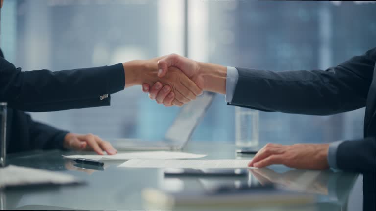 Female and Male Business Partners Sign Successful Deal Documents and Shake Hands in Meeting Room Office. Corporate CEO and Investment Manager Handshake on a Lucrative Financial Opportunity.