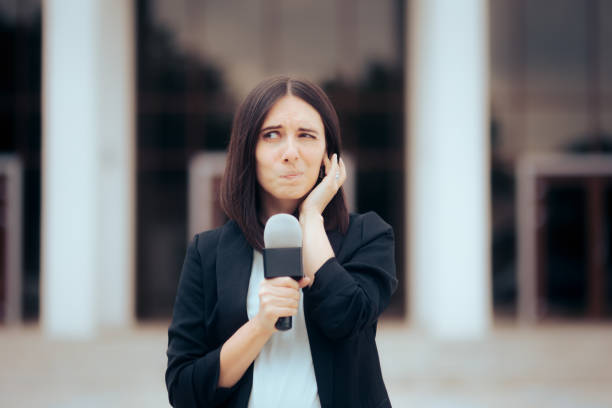 istock Female Reporter Fitting Earpiece preparing to Go Live 1346455631
