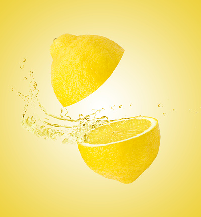 Lemon juice spilling isolatred on yellow background.