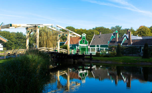 Historic dutch village with little green gable houses, windmill and drawbridge in front of a lake. Arnhem in the Netherlands. Tourism and vacations concept.