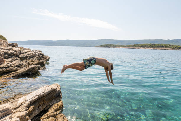 istock Man dives onto beautiful clear water 1346482568