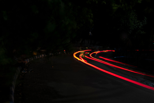 Car Light trails on a city street in a dark black night. Photo is taken with long exposer.