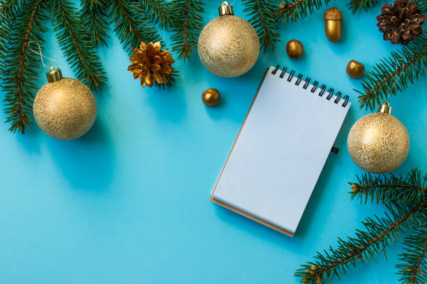 istock New Year's background with spruce branches, golden balls, nuts, cones, notebook page layout. top view. 1346483484