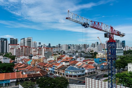 Singapore, Oct 11, 2021 Crane on HDB contraction site against Singapore cityscape on a sunny morning. Horizontal shot