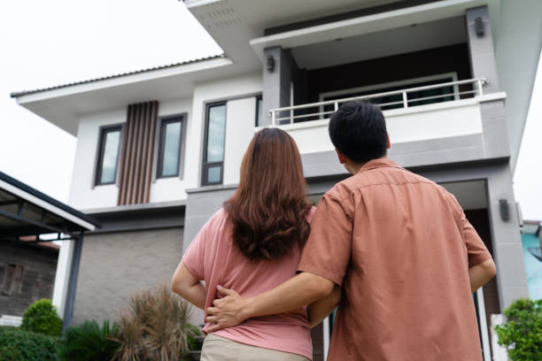 istock couple standing outside and looking their house 1346485870