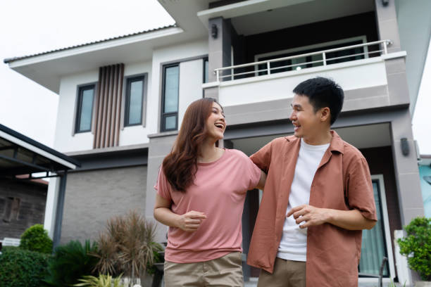 istock cheerful couple standing outside their house 1346485873