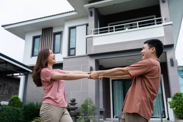 istock cheerful couple standing outside their house 1346485876