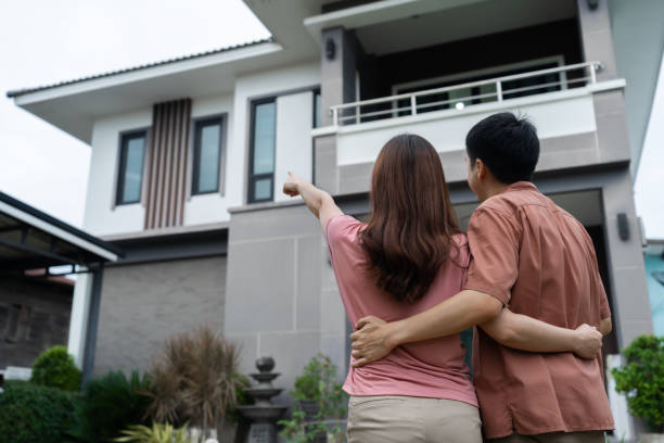 istock couple standing outside and looking their house 1346485877