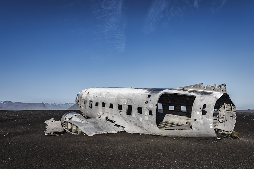 Crashed DC-3 Airplane Wreck in Iceland on lava beach at Sólheimasandur under blue summer skyscape. Wreck of Dakota United States Navy Douglas Super DC-3 Wreck on Sólheimasandur Beach. Panorama Shot. DC-3 Airplane Wreck, Southern Iceland, Iceland, Northern Europe.