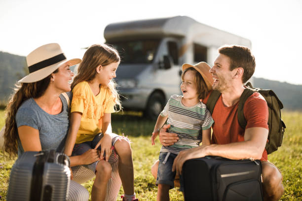 istock Happy family talking before their trip with camper trailer. 1346489973