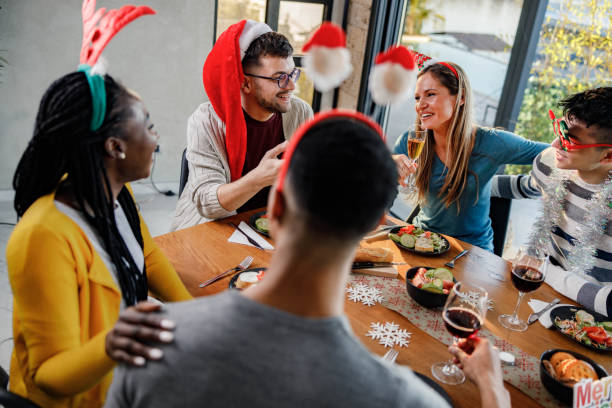 istock Happy friends talking during Christmas lunch at dining table. 1346492405