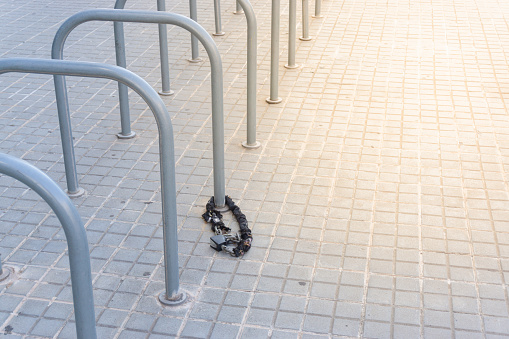 Abandoned padlock and chain in a public bicycle parking lot