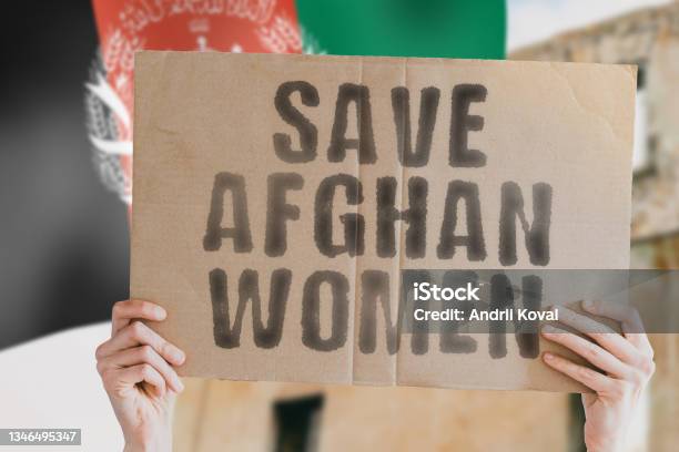 The Phrase Save Afghan Women On A Banner In Mens Hand With Blurred Afghan Flag On The Background Protest Riot Violence Collapse Politics Streets Save Cruelty Religion Help Afghanistan Stock Photo - Download Image Now