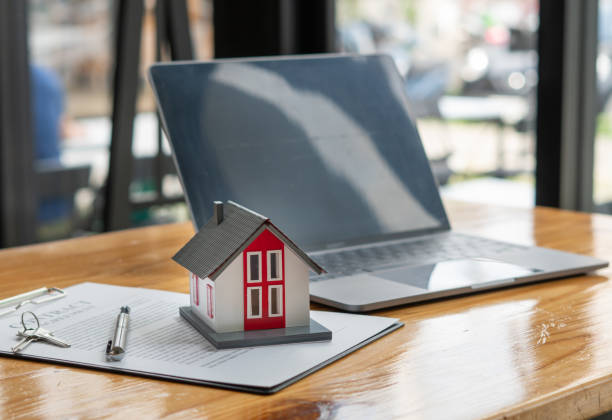 istock House model and house purchase agreement on office desk 1346495552