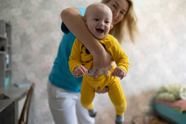 istock Baby boy playing with his mom at home 1346496366