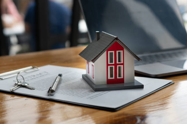 istock House model and house purchase agreement on office desk 1346496386