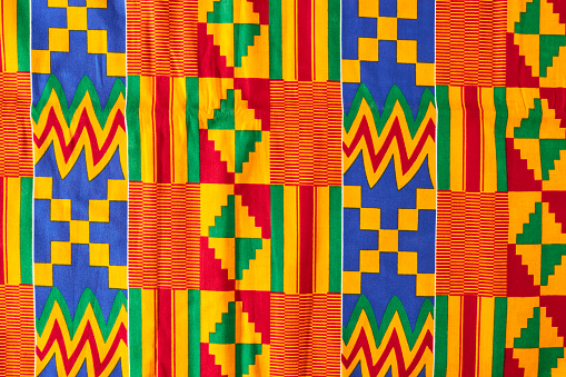 African Ghanaian colourful fabrics in a pile spread out on a table