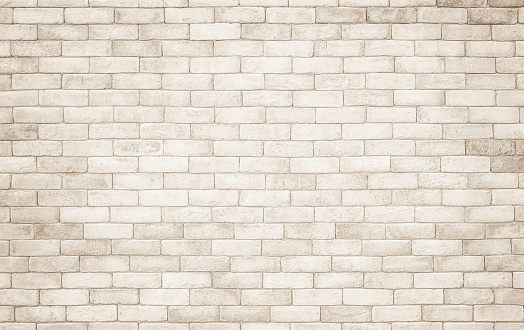 Cream and white brick wall texture background. Brickwork and stonework flooring interior rock old pattern clean concrete grid uneven bricks design stack. Background of old vintage brick wall