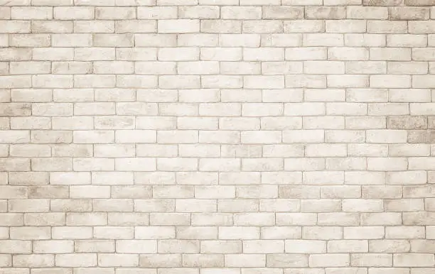 Photo of Cream and white brick wall texture background. Brickwork and stonework flooring interior rock old pattern clean concrete grid uneven bricks design stack. Background of old vintage brick wall