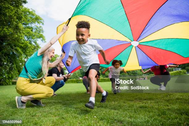 School Children With A Parachute Stock Photo - Download Image Now - Playing, Playful, Outdoors